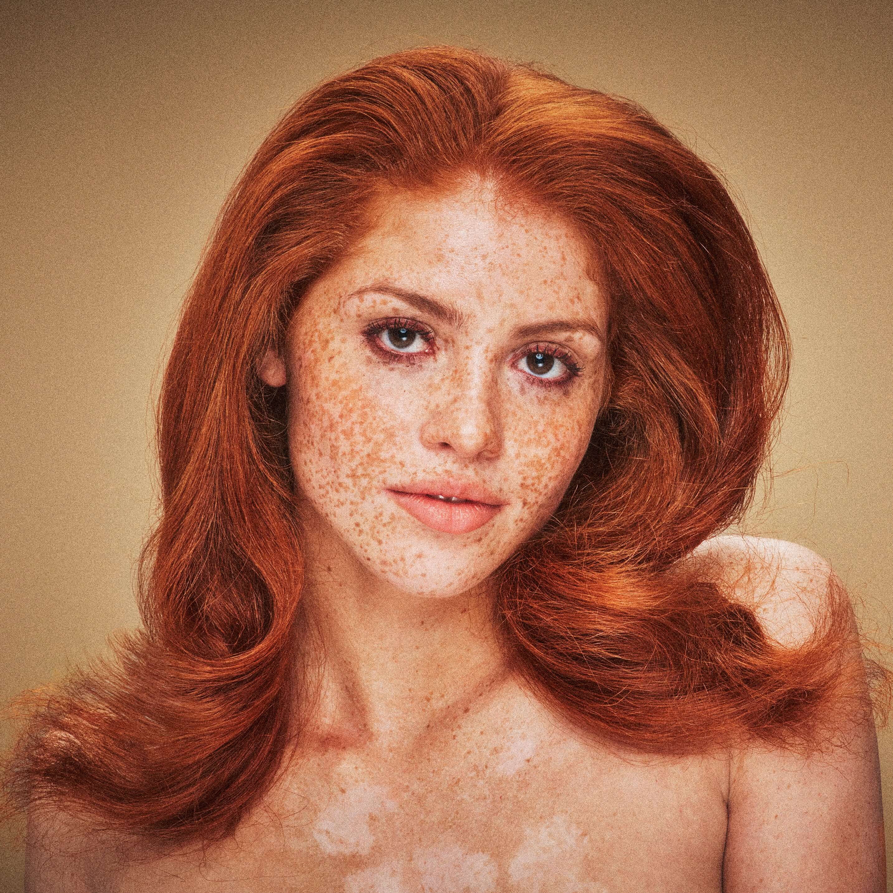 Red-haired woman with medium-length hair, freckles, and glowing skin. Her styled wavy hair highlights the nourishing benefits of Blake Brown by Blake Lively.