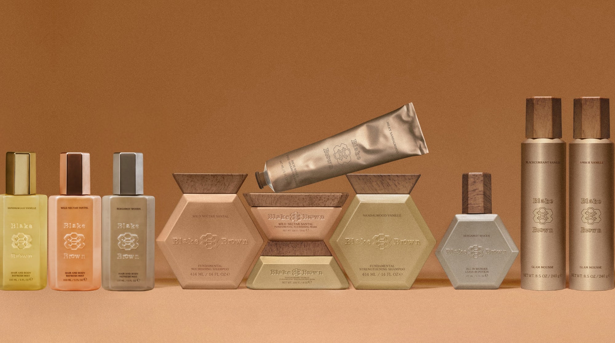 Full Blake Brown hair product collection displayed on a warm brown background, complete with the new Hair & Body Refresh Mists.
