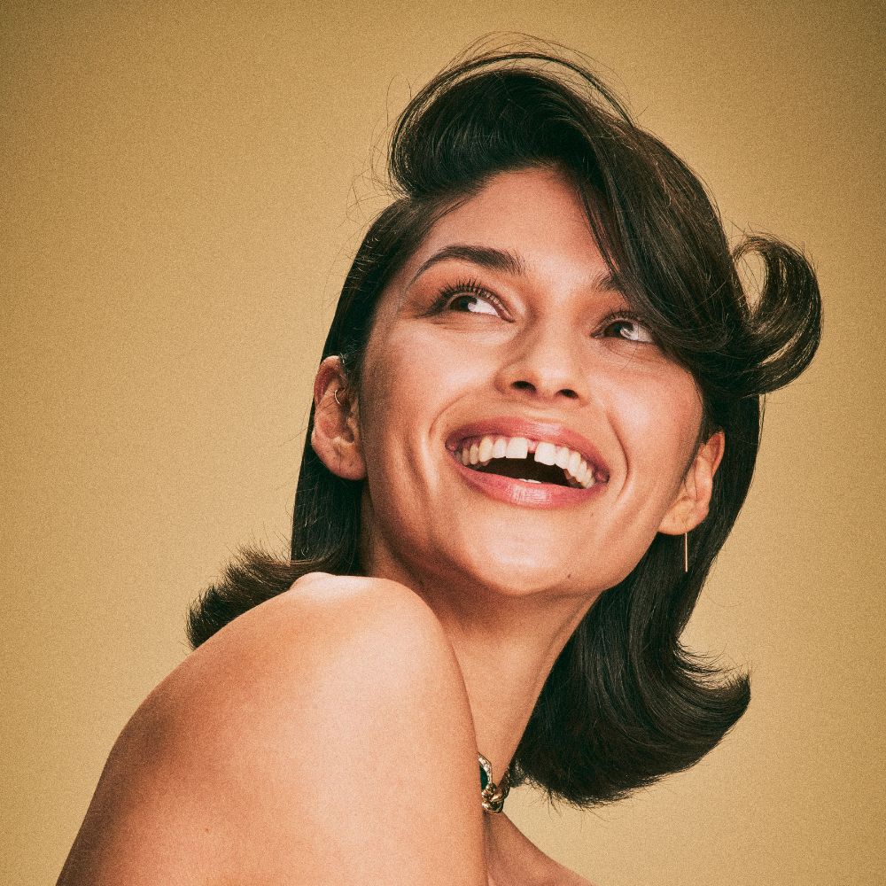 Woman with dark, shiny, healthy-looking hair—the result of using Blake Brown's iconic haircare products.