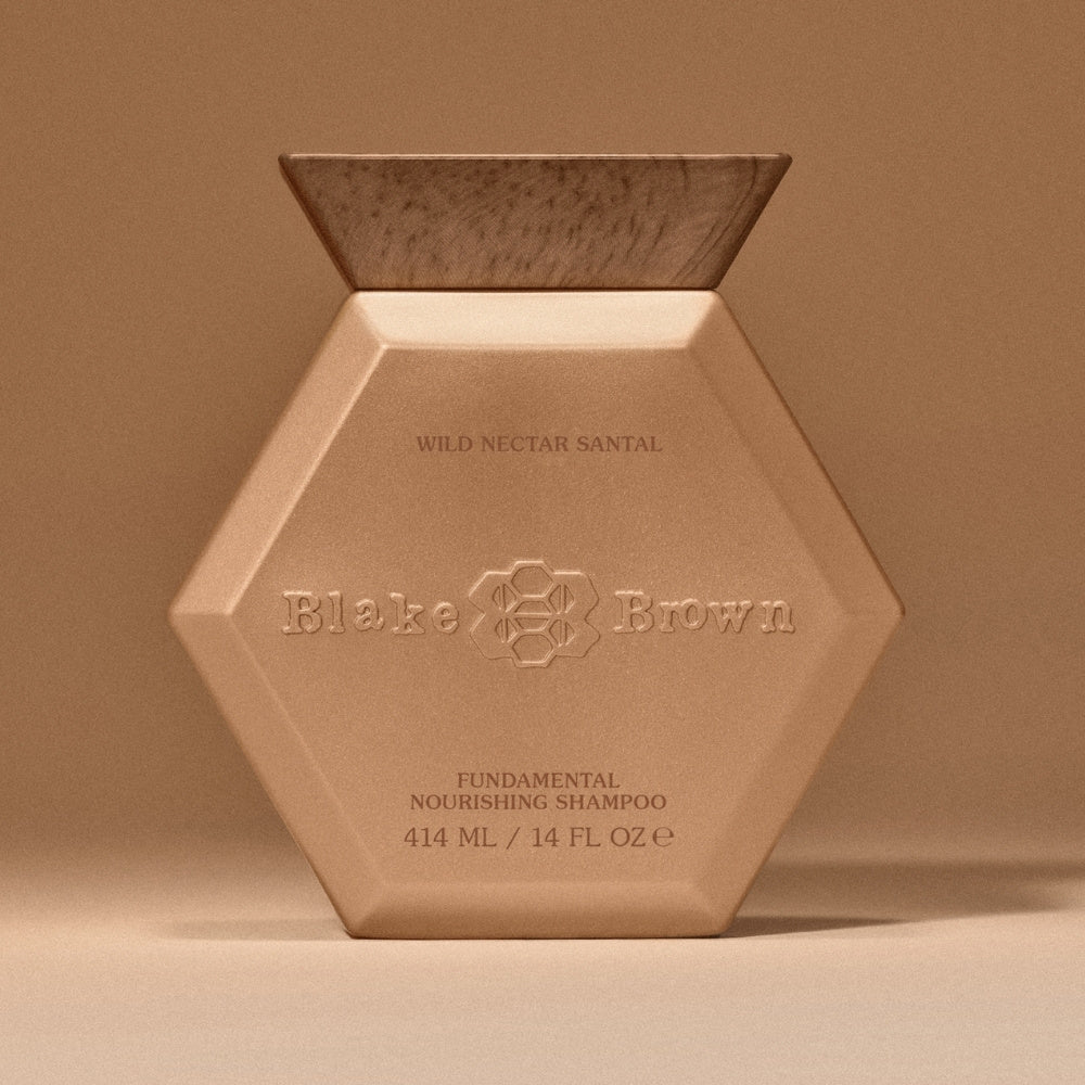 Blake Brown Nourishing Shampoo in a brown bottle with a wooden lid, designed to visibly smooth hair and tame frizz.