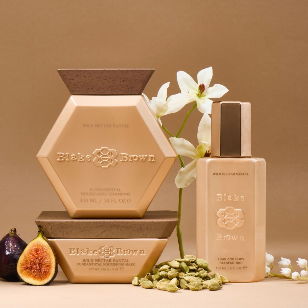 Blake Brown Wild Nectar Santal haircare trio—Nourishing Shampoo, Nourishing Mask, and Hair and Body Refresh Mist—styled with figs and white flowers.