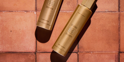 Blake Brown Dry Shampoo and Glam Mousse lying side-by-side on a tiled floor.