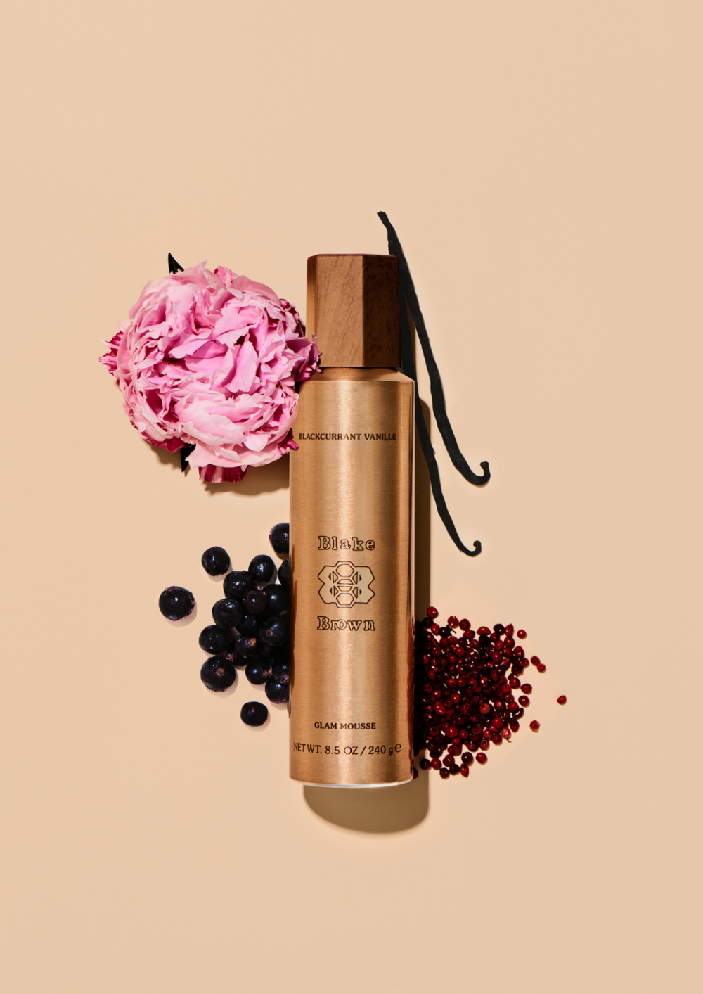 Blake Brown Glam Mousse styled with blackcurrant, pink peppercorn, vanilla, and a pink peony to highlight its Blackcurrant Vanille fragrance.