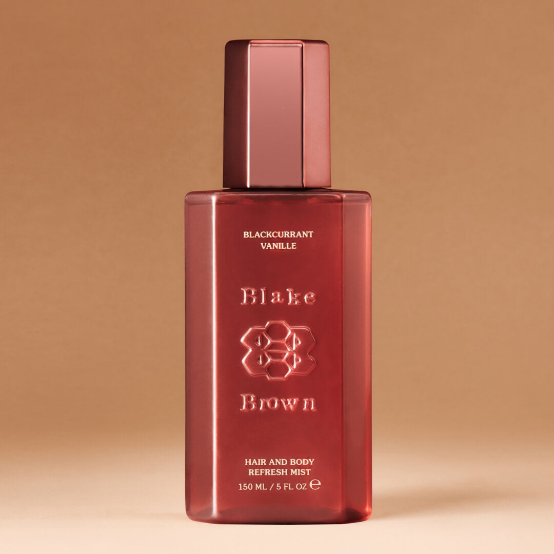 Red bottle of Blake Brown hair and body refresh mist on a beige background