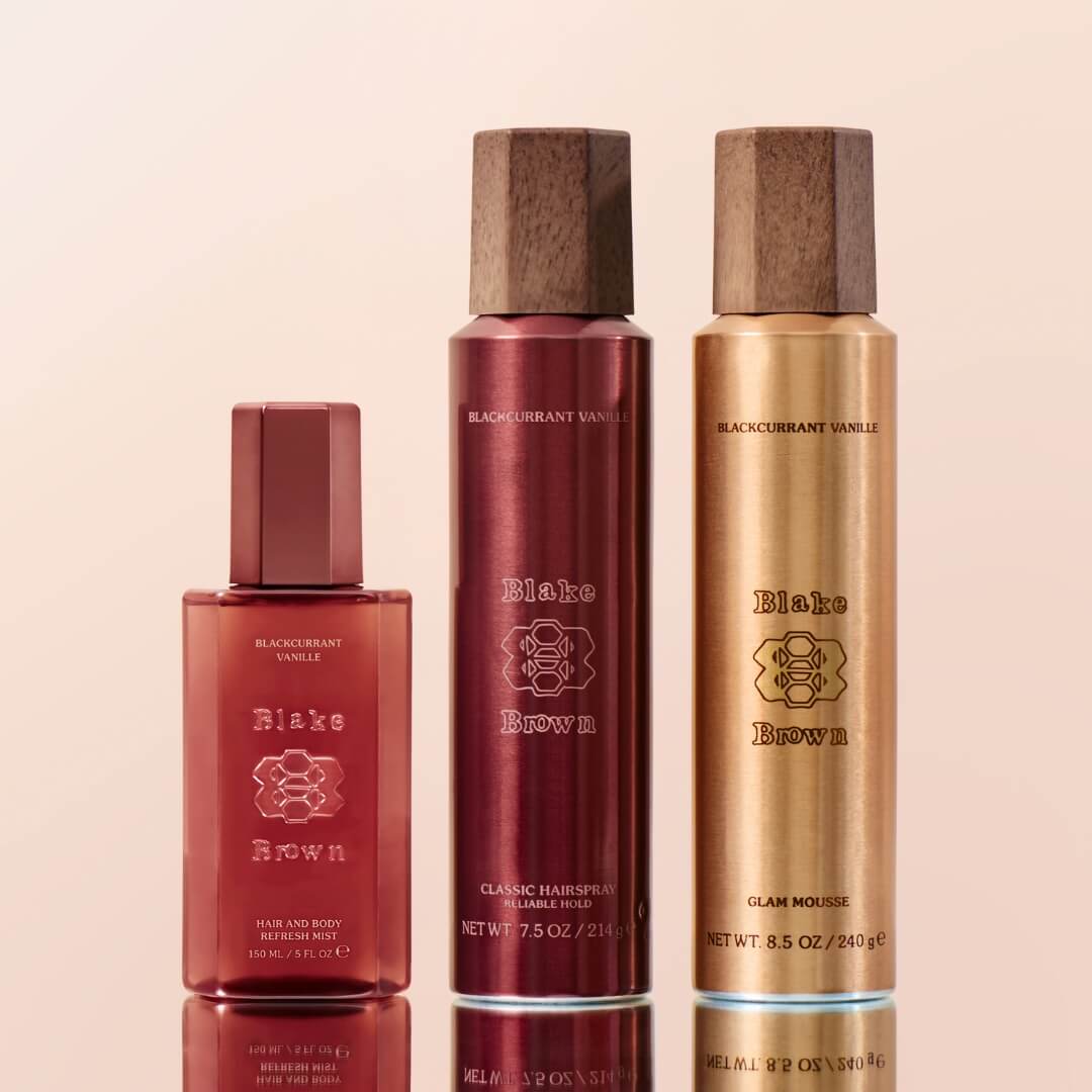 Three hair care products with wooden caps on a beige background