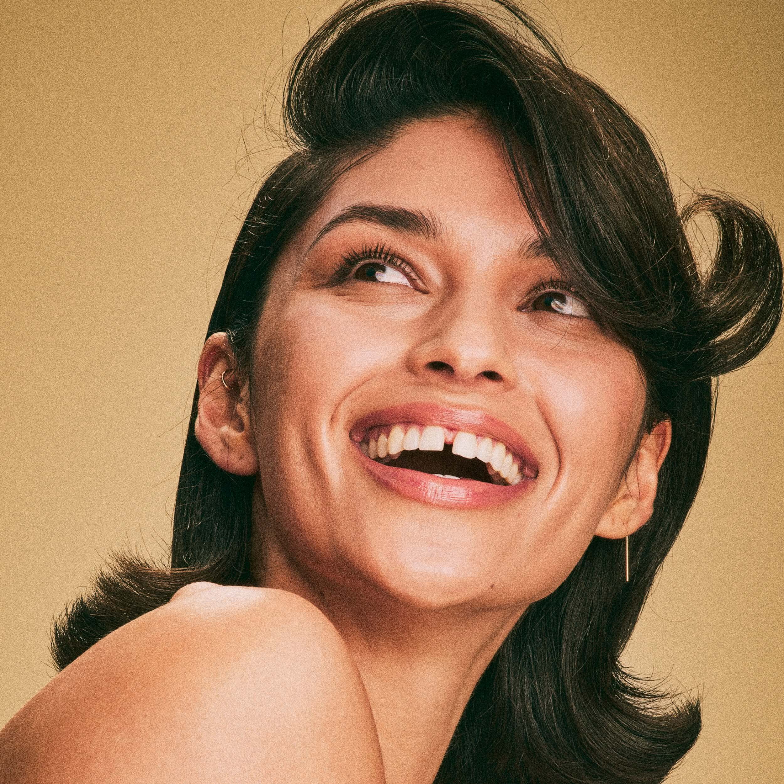 Blake Brown hair model with short brown hair and a cute wave, smiling after using the Every Wash Strengthening Trio by Blake Lively.